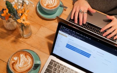 Laptops on a table next to cups of coffee