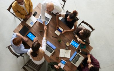 Team meeting at table with laptops